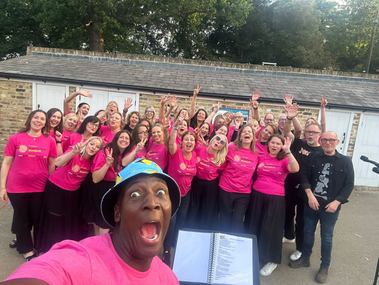 SLYMI celebrating after a charity performance in Brain Tumour Research shirts