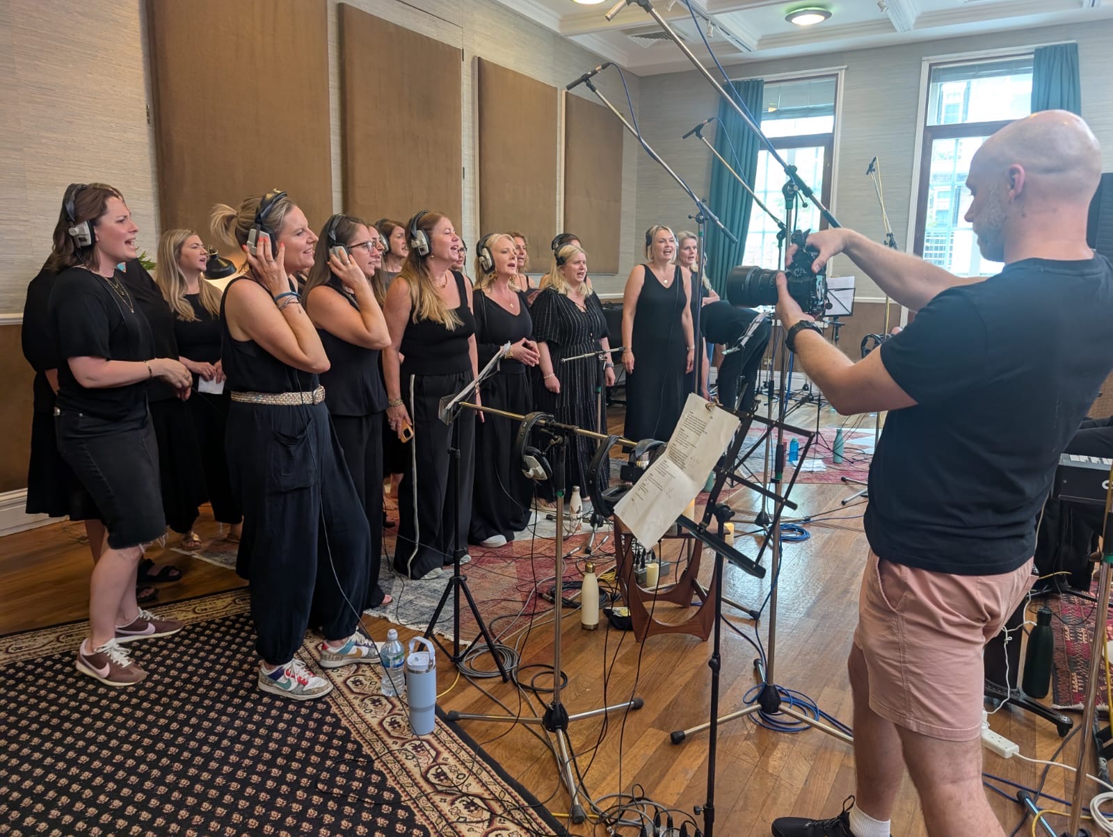 SLYMI members being filmed while recording in a London studio