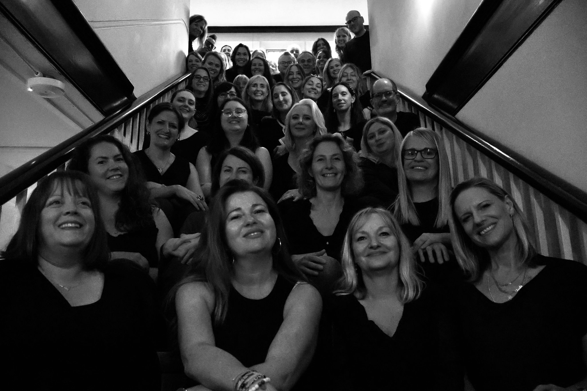 SLYMI choir members together on the studio staircase