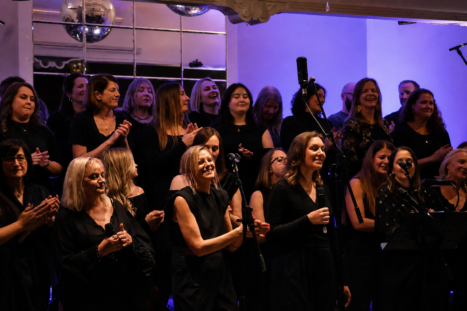 SLYMI choir celebrating during a live performance