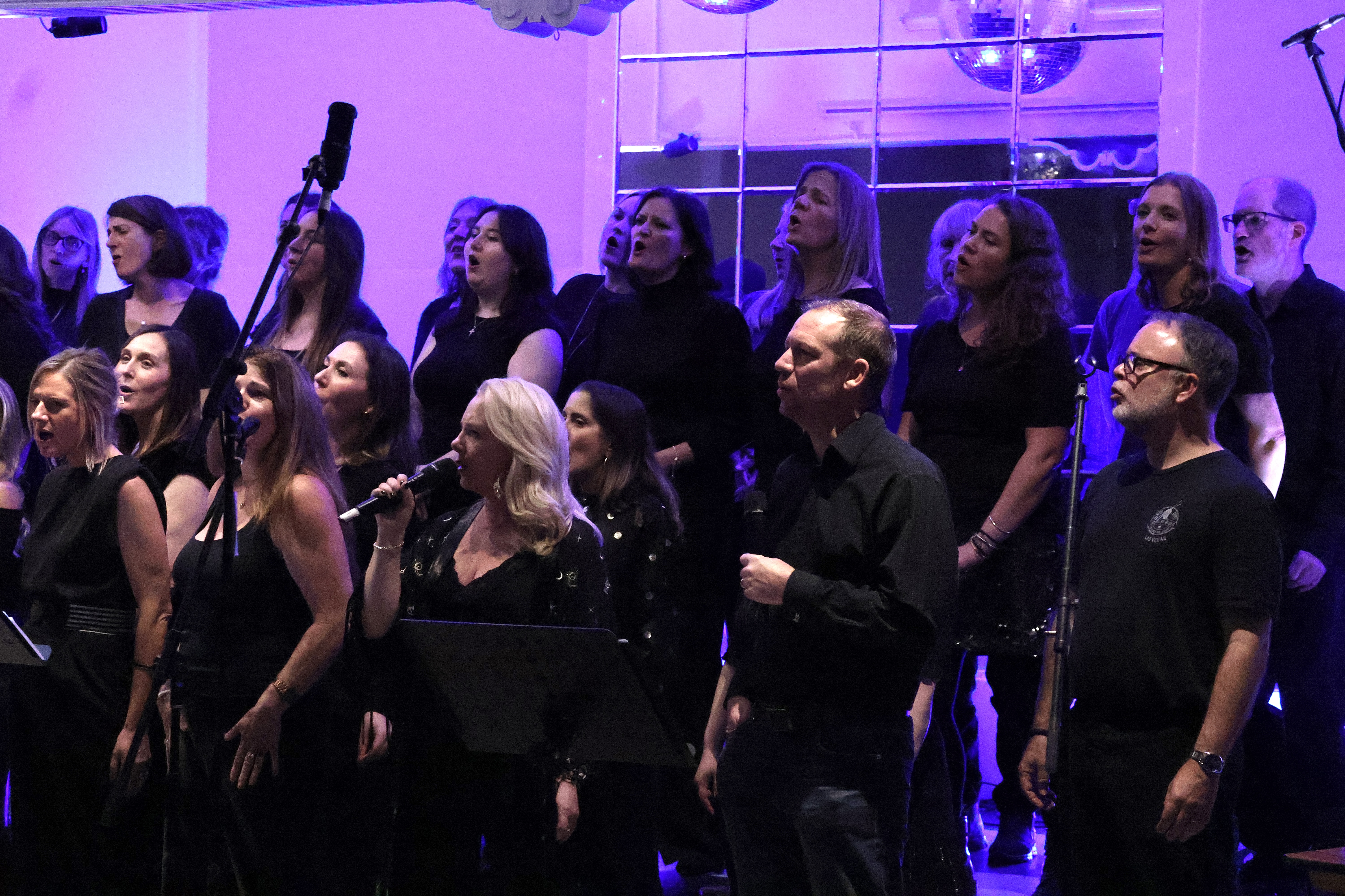 SLYMI choir performing live under stage lights